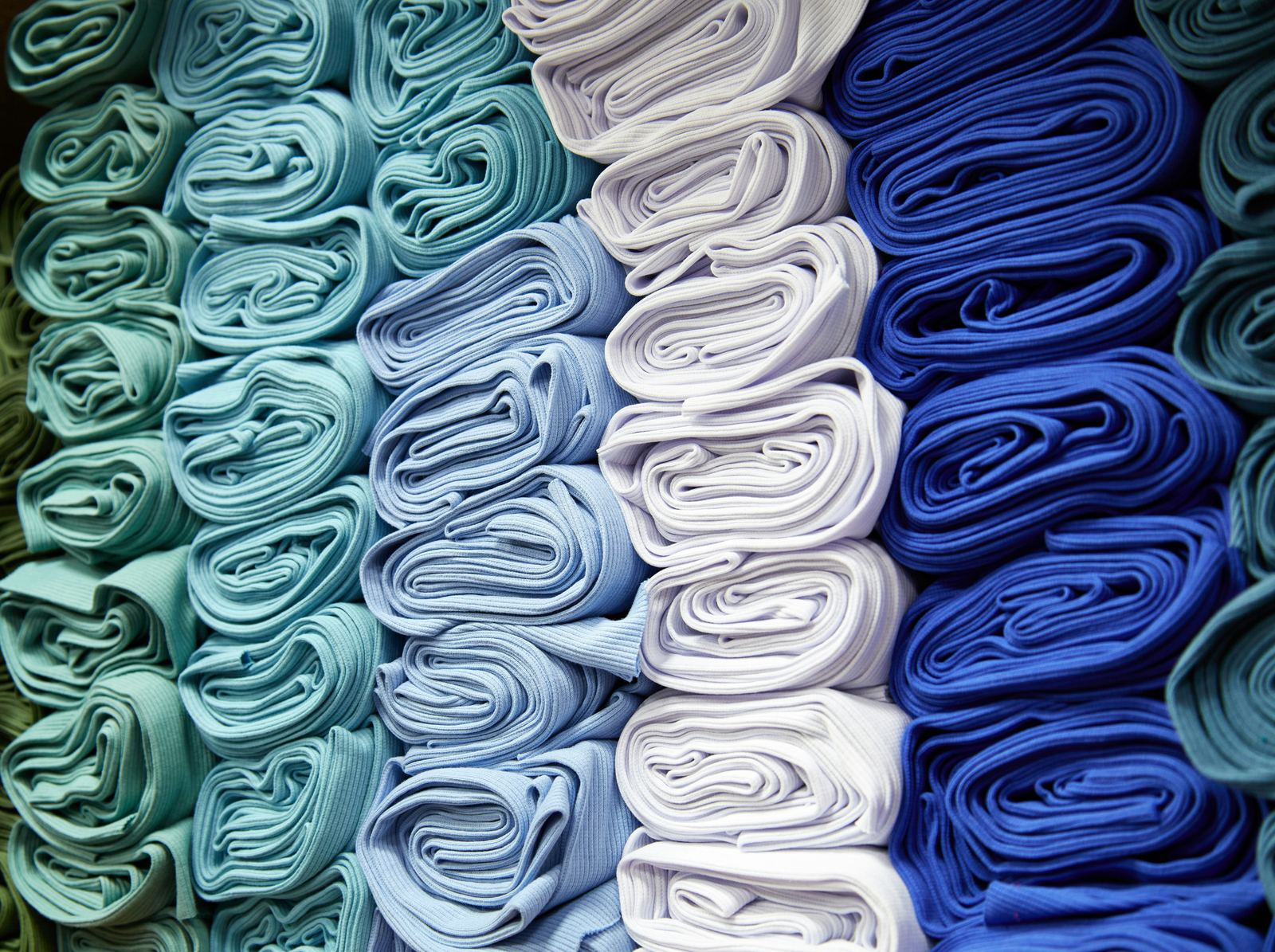 Rouleaux de tissu satin bleu, turquoise et blanc