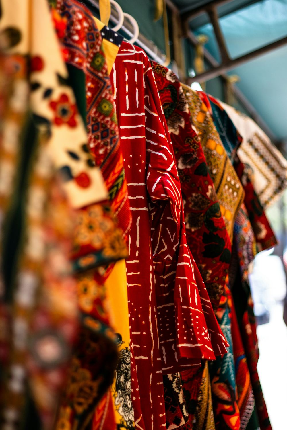 Vêtements en wax rouge et orange sur un portant